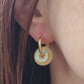 Close up of a woman wearing vintage-inspired enamel disc earrings with yellow glass drop and gold-plated hoops.