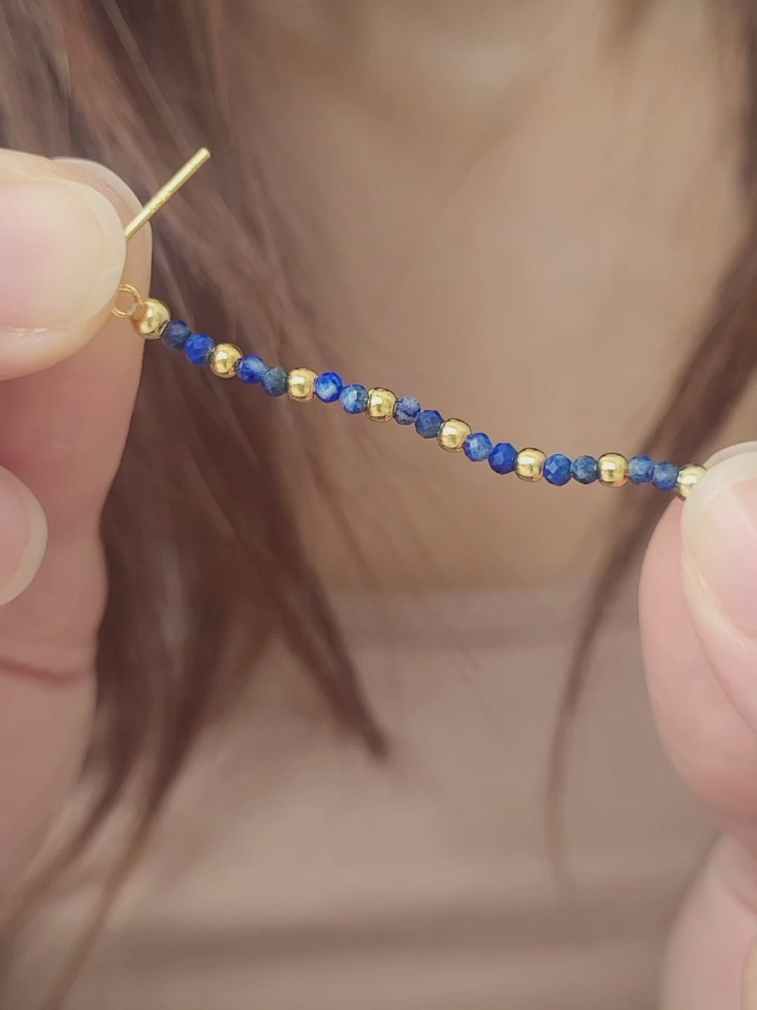 Close-up of a gold and blue beaded earring worn on an ear. Perfect birthday gift for mom