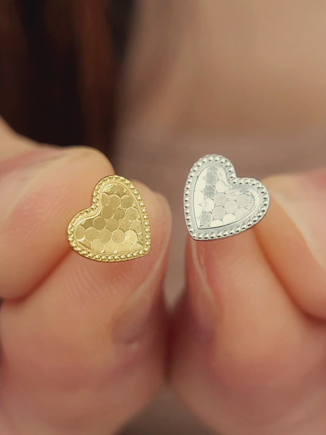 Close up of a pair of heart stud earrings feature subtle textured surface with a fine beaded edge detail. Crafted in 18k gold plated sterling silver.