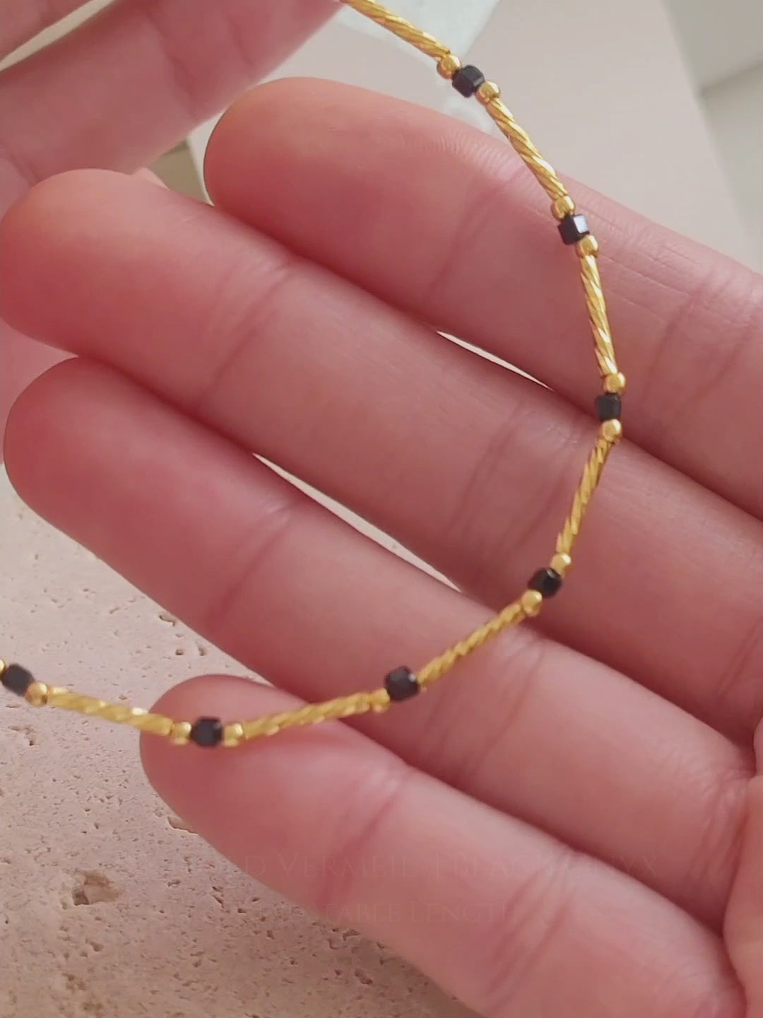 Close-up of a 22k gold vermeil choker necklace with black onyx beads worn around the neck. Crafted in 22k gold plated over sterling silver and natural gemstone. Perfect gift for mom.