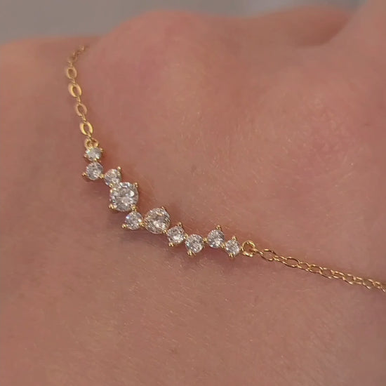 Close-up of a dainty gold necklace with curved cubic zirconia pendant, perfect anniversary gift for her.