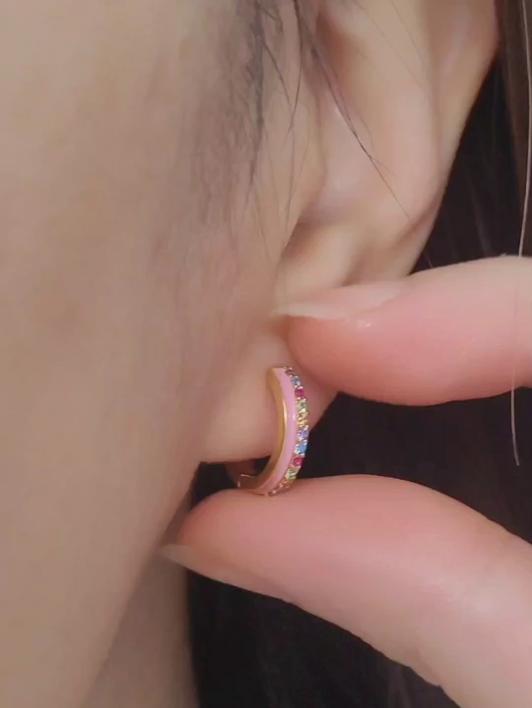 Close up of a woman wearing statement pink enamel hoop earrings with rainbow crystal styled for a boho chic look. Crafted in gold plated sterling silver.