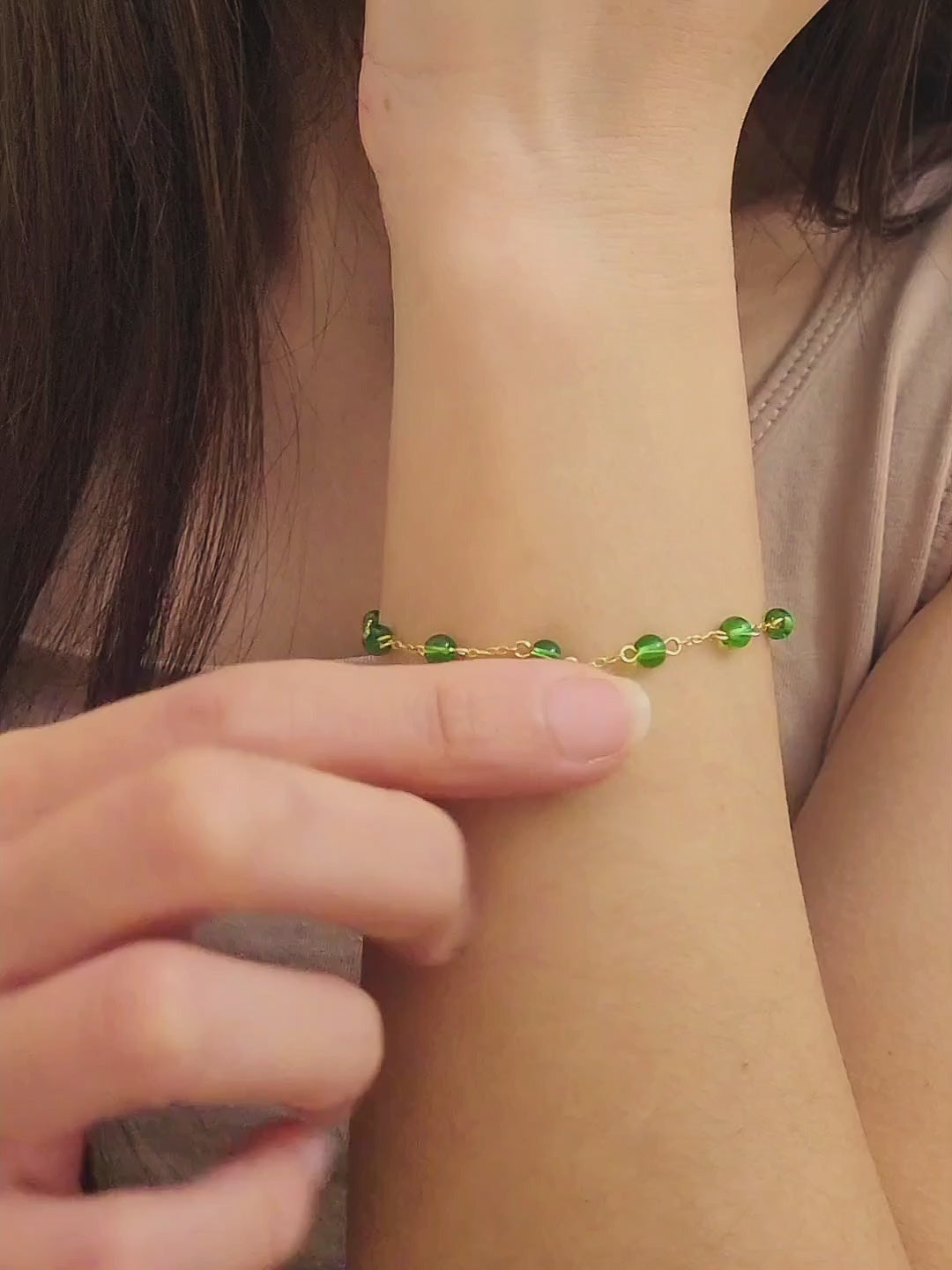 Elegant gold chain bracelet with green gemstone beads and a dainty pearl drop, perfect for a minimalist look.