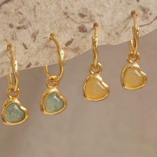 Woman wearing cute and dainty yellow heart dangle gold earrings, crafted in natural quartz crystal gemstone. Perfect anniversary gift for girl.