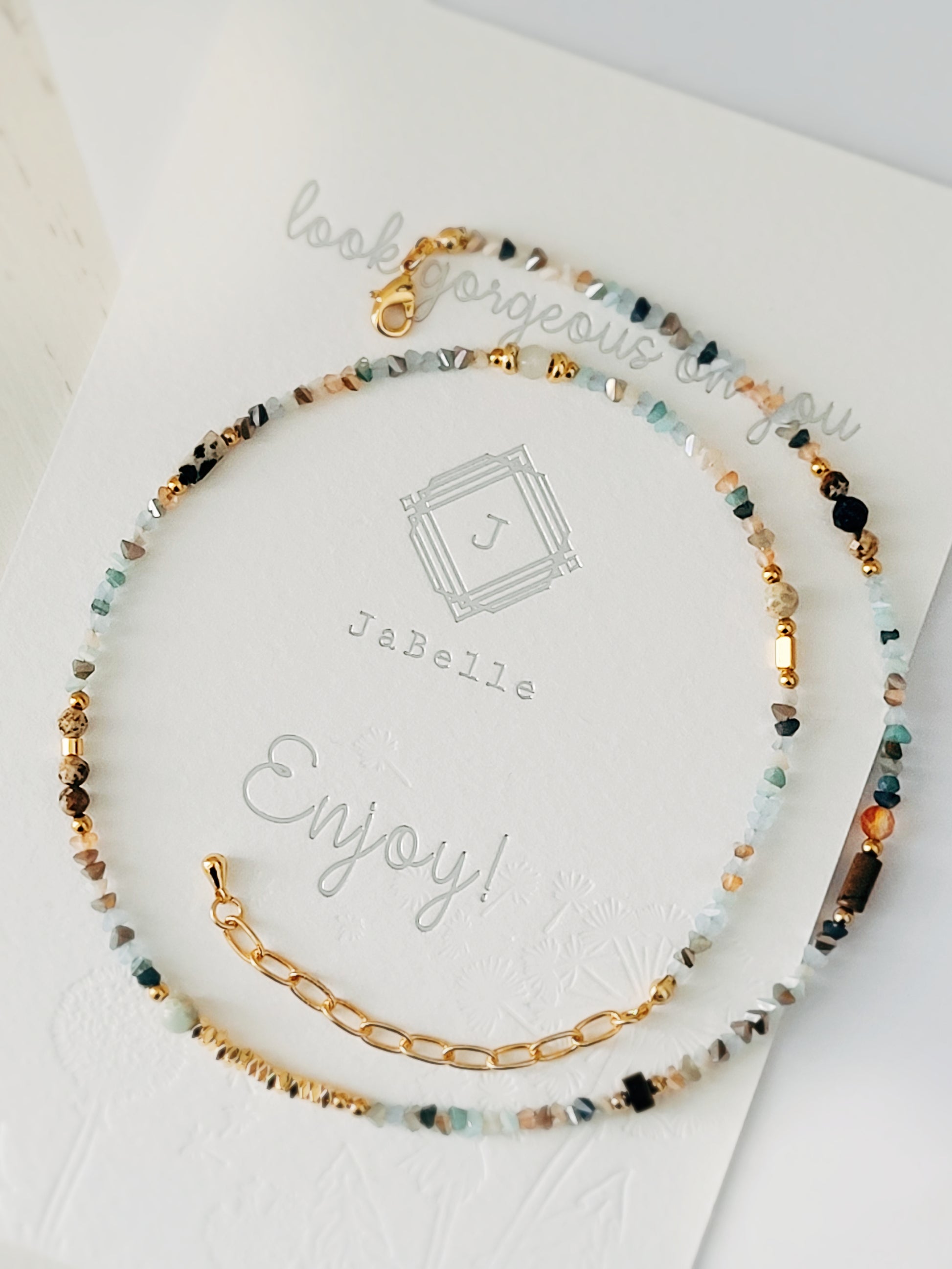 A luxurious rainbow gemstone necklace adorned with a captivating array of multi-colored gemstones, including Jaspers, crystals, tiger eye and gold vermeil beads. Perfect for any occasion.