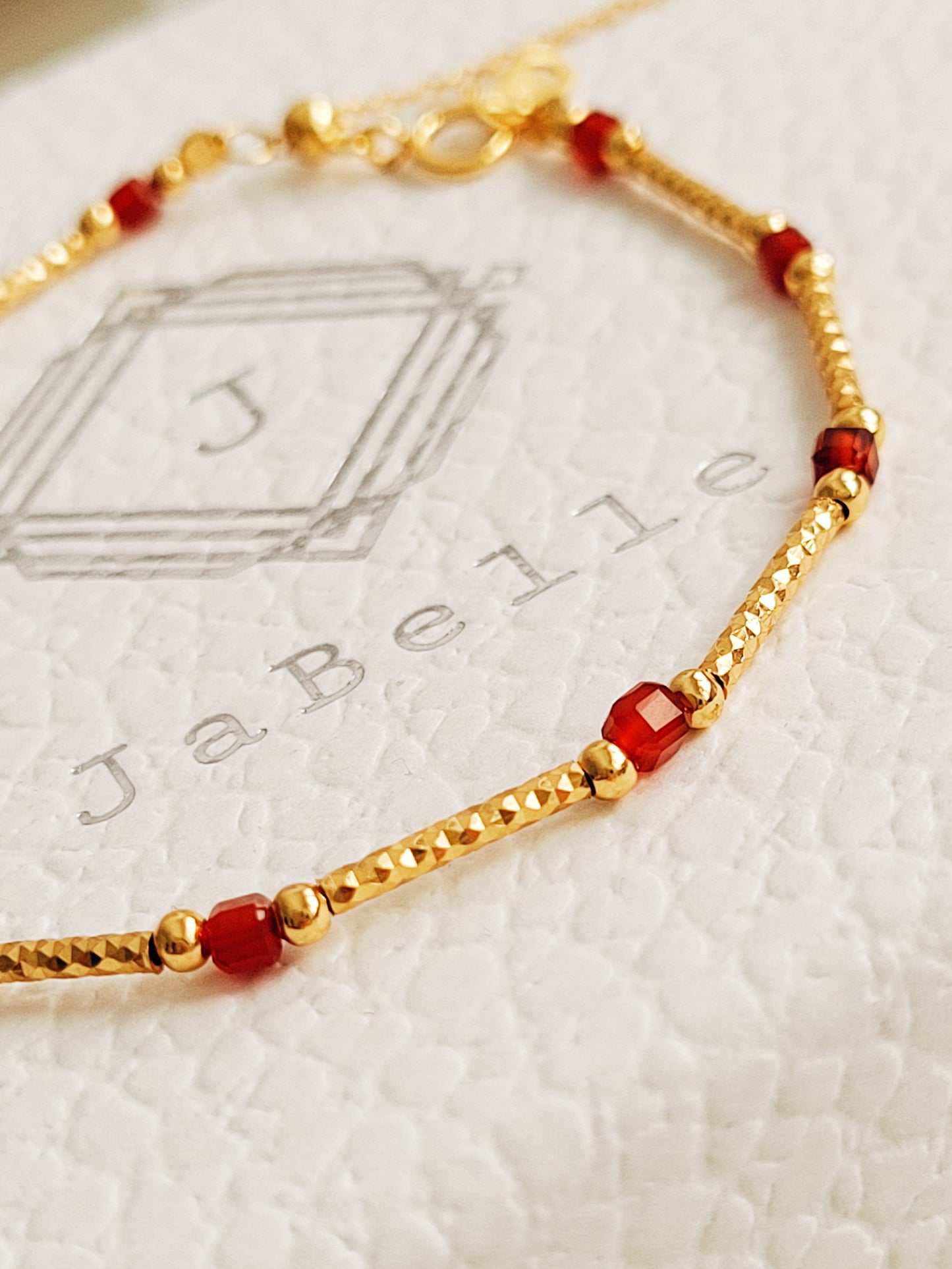 Close-up of a red onyx and gold beaded gemstone bracelet, featuring vintage-inspired elegance and dainty gold chain details. Crafted in gold plated sterling silver, perfect anniversary gift, birthday gift for her.
