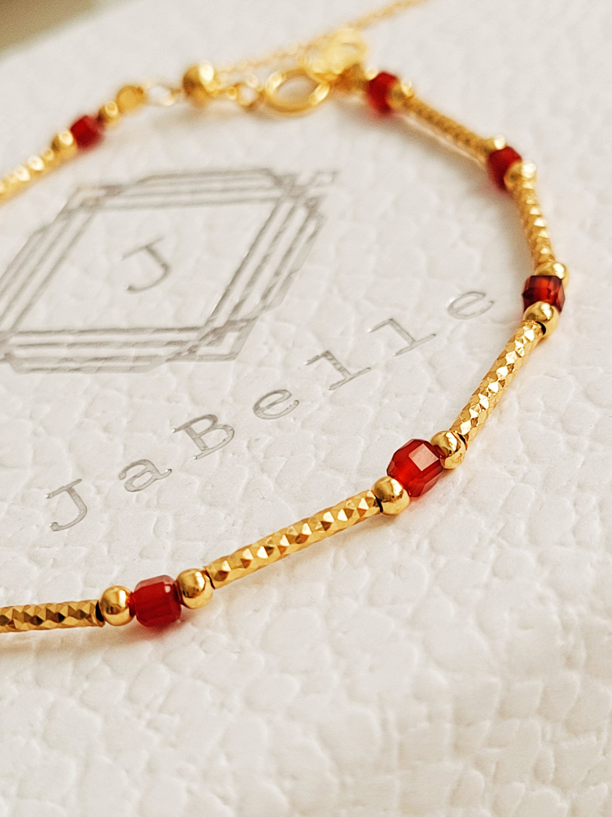 Close-up of a red onyx and gold beaded gemstone bracelet, featuring vintage-inspired elegance and dainty gold chain details. Crafted in gold plated sterling silver, perfect anniversary gift, birthday gift for her.