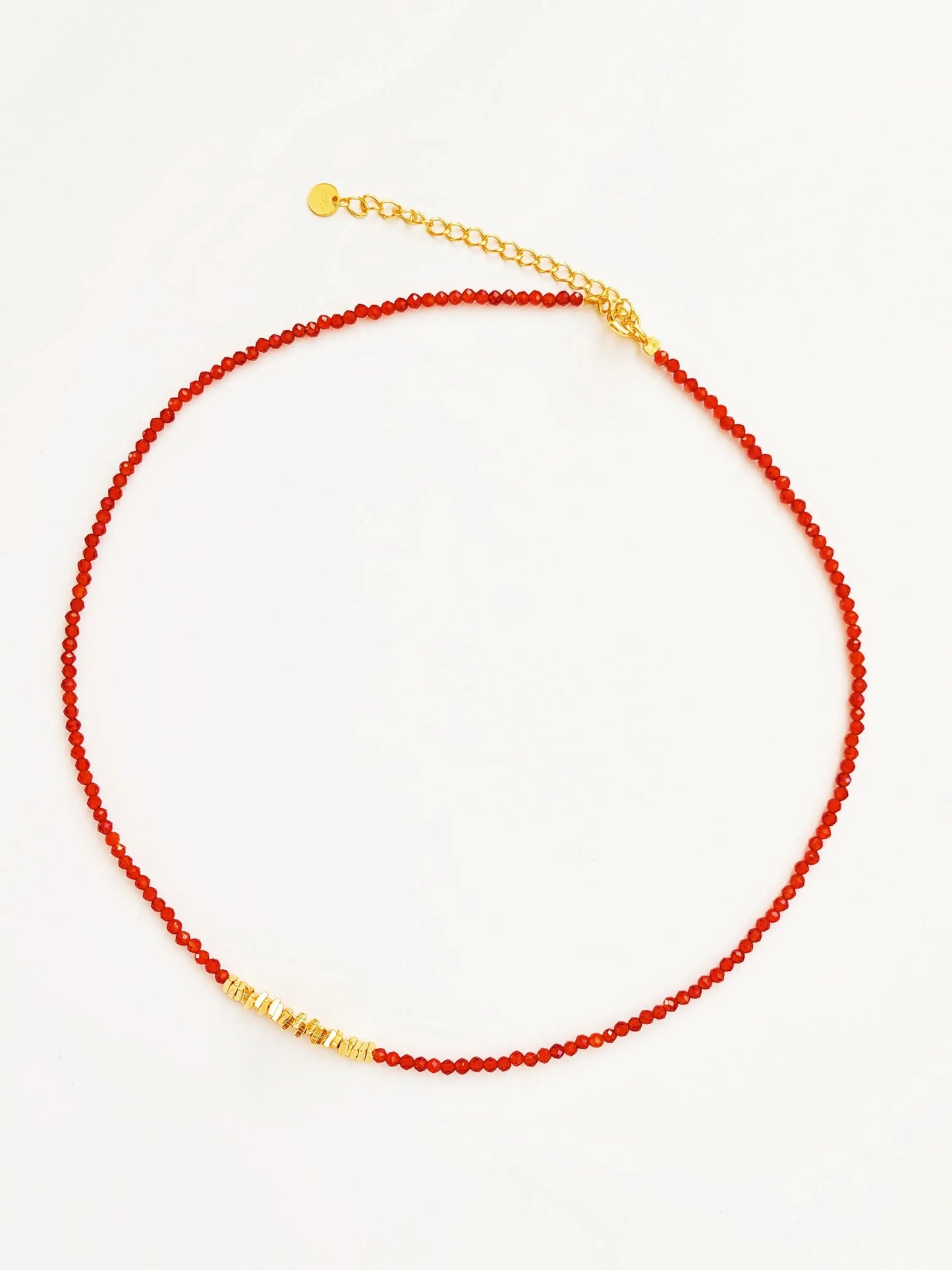 Necklace with red beaded onyx gemstone and gold beads on a white background