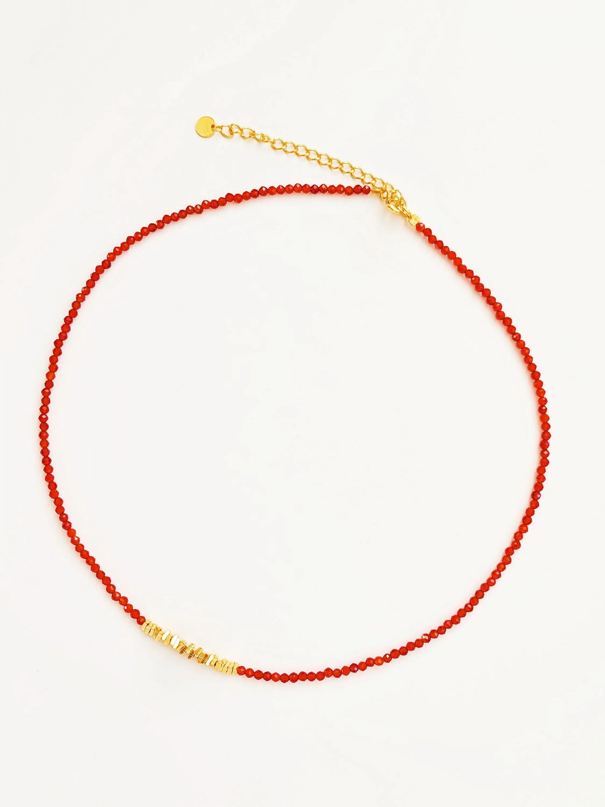 Necklace with red beaded onyx gemstone and gold beads on a white background