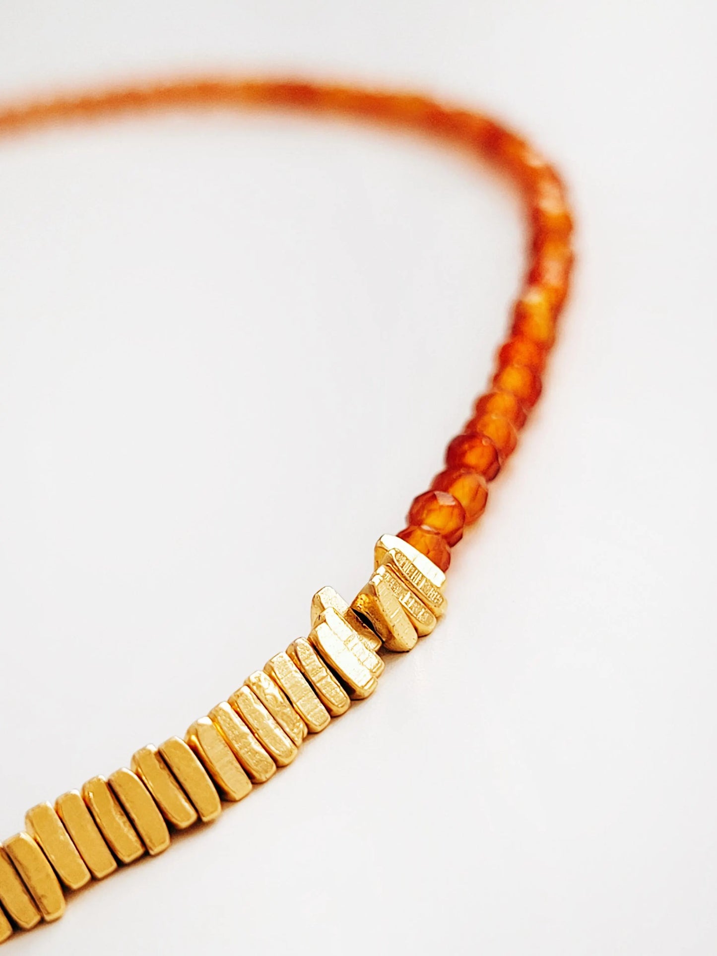 Close up of a red onyx gemstone choker necklace featuring 22k gold vermeil triangular beads, dainty and stylish jewellery