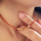 Close-up of a woman wearing a red onyx beaded gemstone necklace with gold vermeil beads, perfect summer beach jewellery