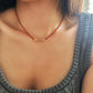 Woman wearing a red onyx choker necklace with 22k gold vermeil beads with knitted casual wear, perfect for summer necklace layering.