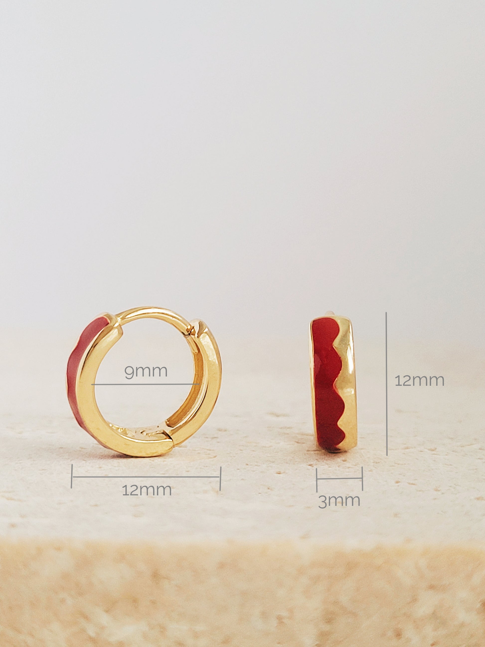 Elegant red wavy enamel wavy huggie hoops, exuding sophistication and charm, perfect for any luxurious occasion.