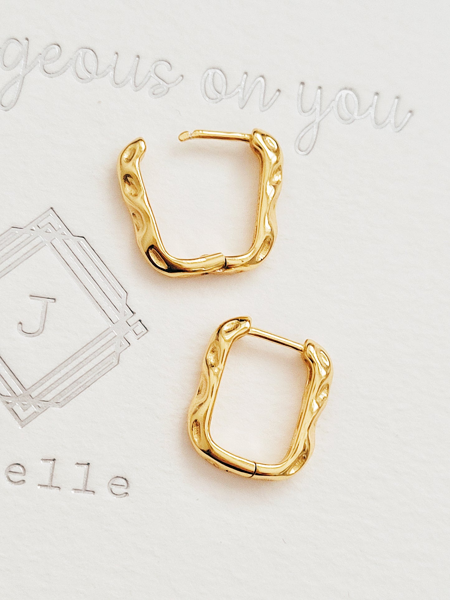 A pair of hammered gold-plated hoop earrings, showcasing a stylish and textured design perfect for any outfit.