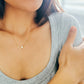 A refined woman wears a stunning gold necklace, accentuated by a delicate star, radiating charm and opulence.
