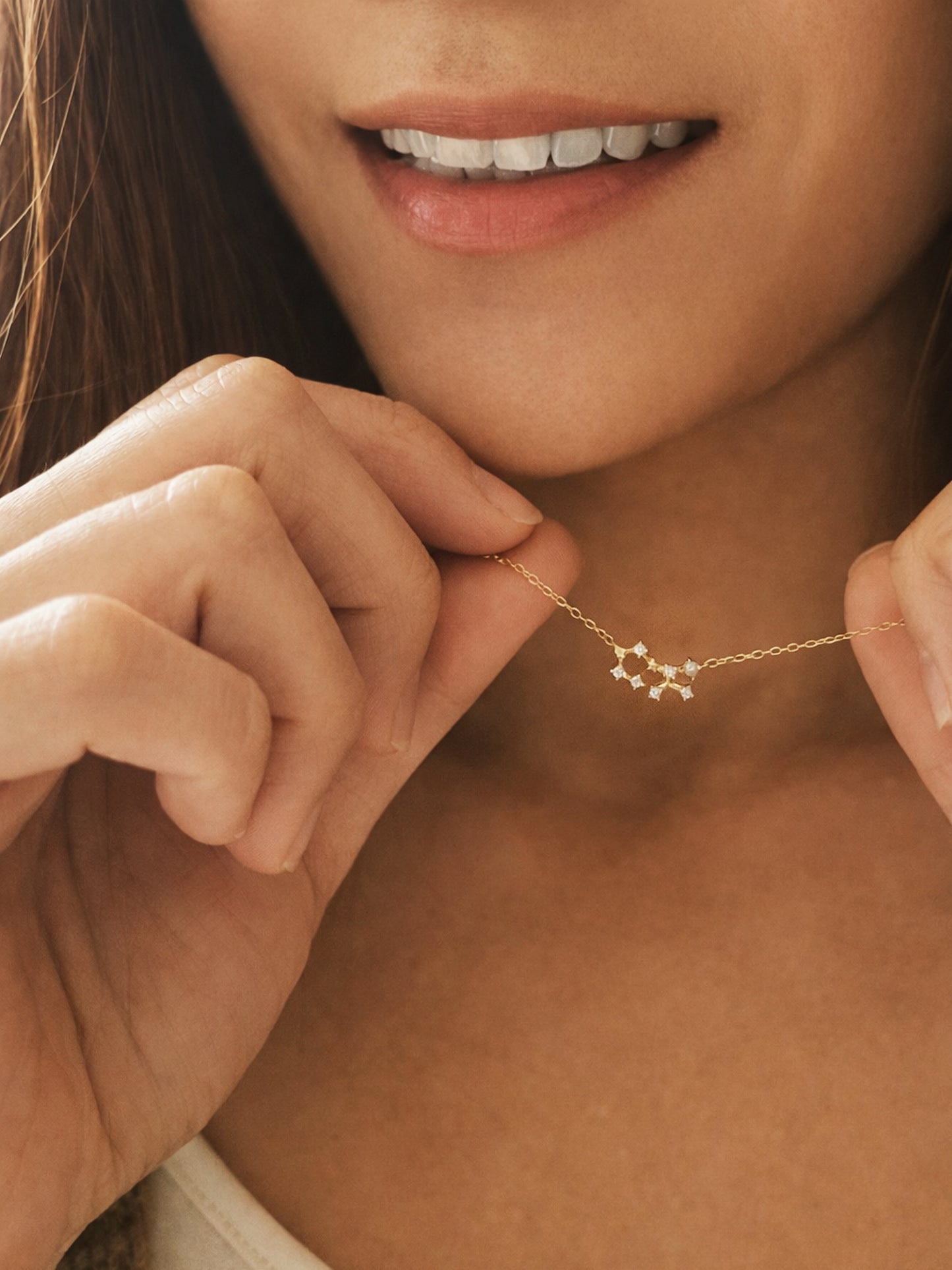 Close-up of a woman wearing a dainty gold sagittarius necklace showcasing the luxury aesthetic and pendant scale.