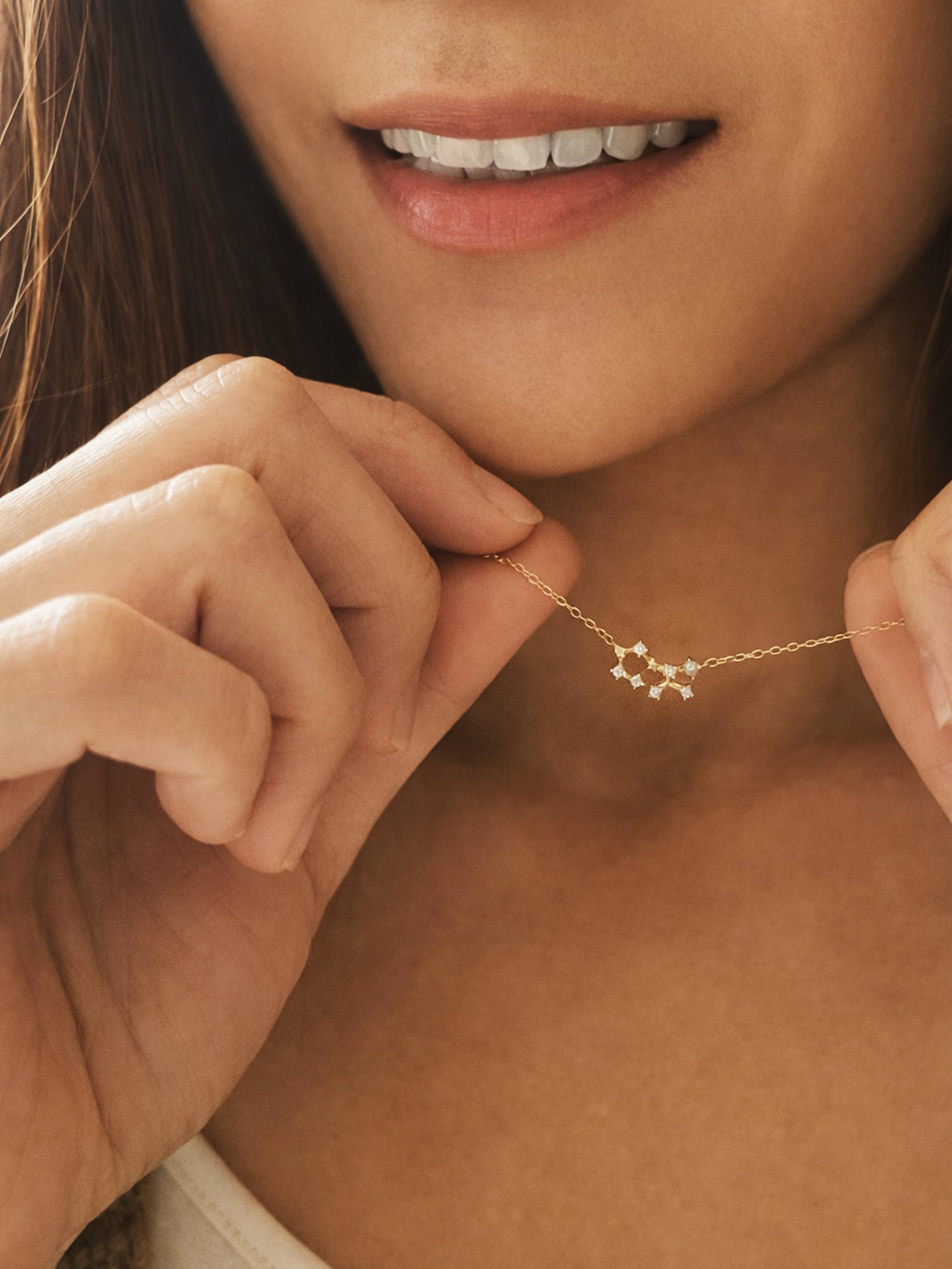 Close-up of a woman wearing a dainty gold sagittarius necklace showcasing the luxury aesthetic and pendant scale.