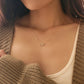 Close-up of a woman wearing a dainty gold sagittarius necklace showcasing the luxury aesthetic and pendant scale.