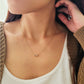 Close-up of a woman wearing a dainty gold sagittarius necklace showcasing the luxury aesthetic and pendant scale.
