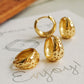 Gold Stars hoop earrings on a piece of paper with 'Enjoy' written on it