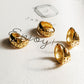 Gold star huggie earrings displayed on a white surface