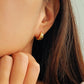 Close-up of a girl wearing a gold earring with stars engraved