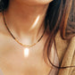 Close-up of woman wearing Tiger’s Eye gemstone choker necklace with 22K gold vermeil nugget beads in natural sunlight