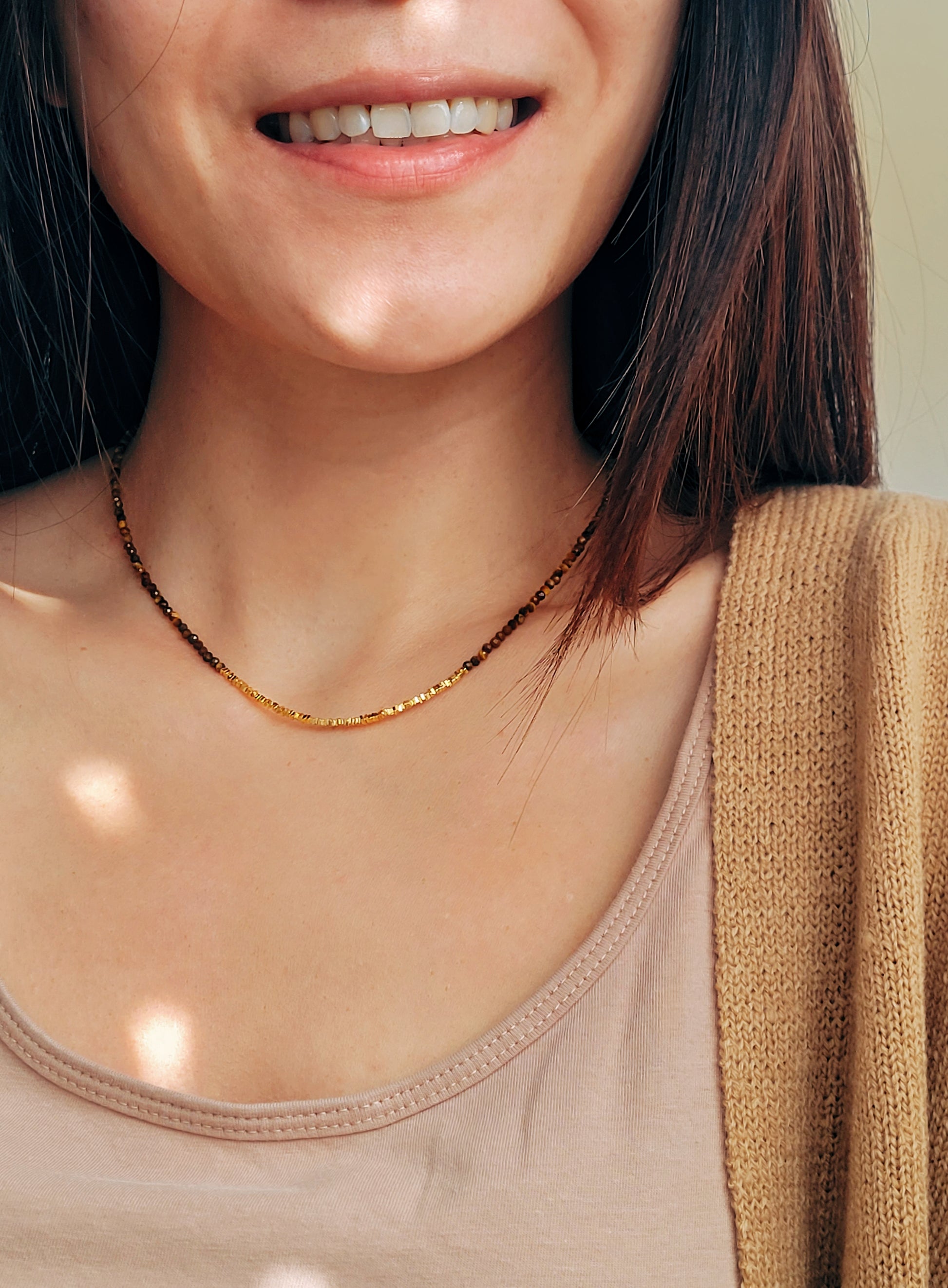 Close-up of woman wearing Tiger’s Eye gemstone choker necklace with 22K gold vermeil nugget beads in natural sunlight