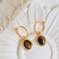 Close-up of gold vermeil dangle earrings with tiger's eye gemstone, minimalist and elegant style.