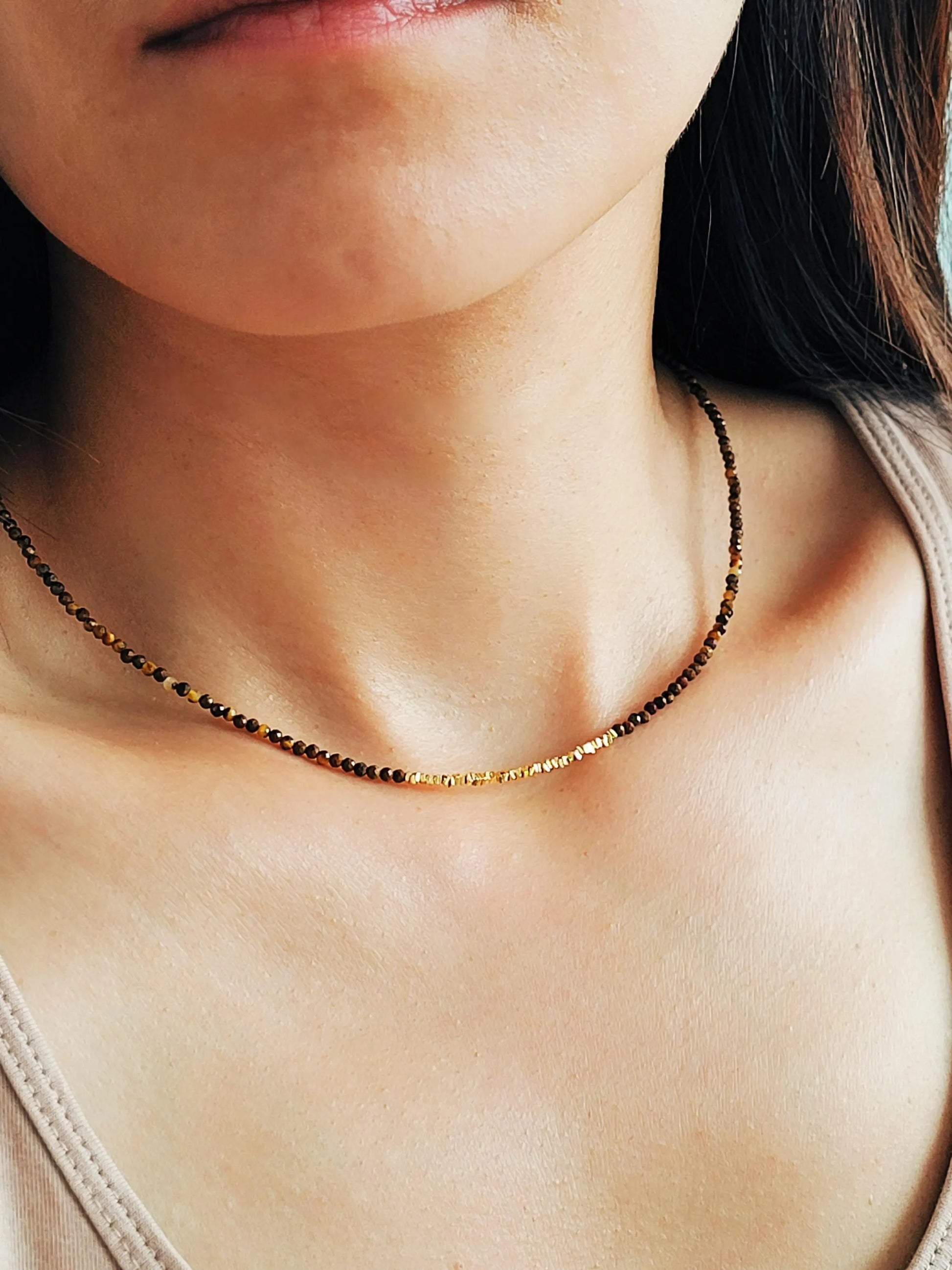 Model wearing a delicate Tiger's Eye Gemstone Necklace with Gold Vermeil Beads.