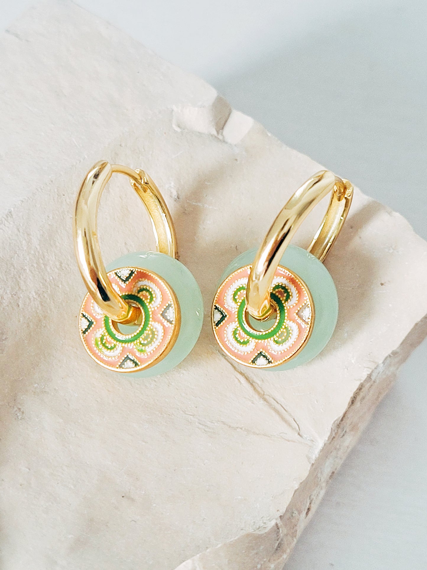 A pair gold vermeil hoop earrings with a green jade drop and enamel tile patter disc, perfect for adding a touch of luxury to any ensemble.