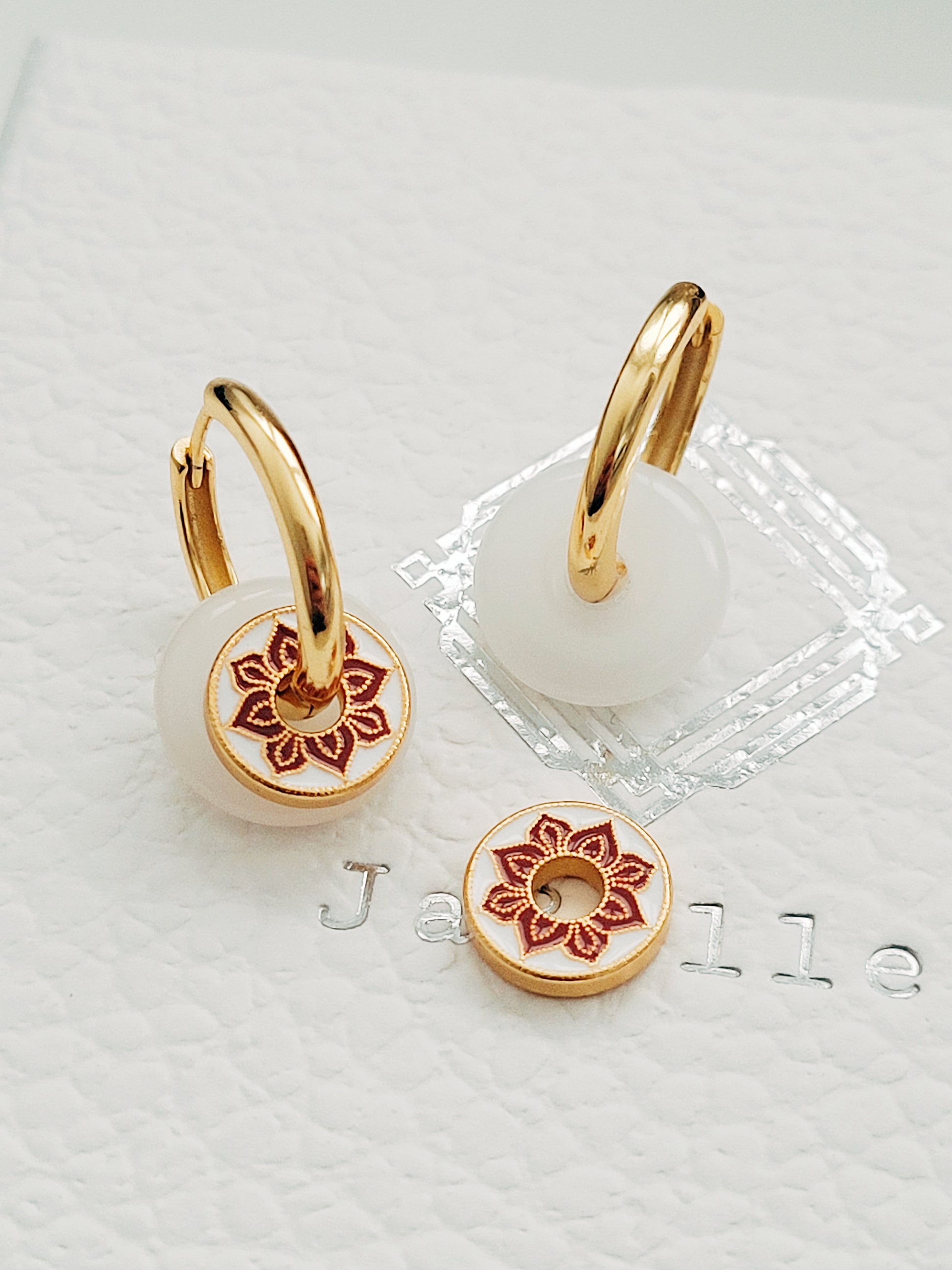 A pair of white jade and enamel disc gold hoop earrings, highlighting the art of vintage ceramic tile.