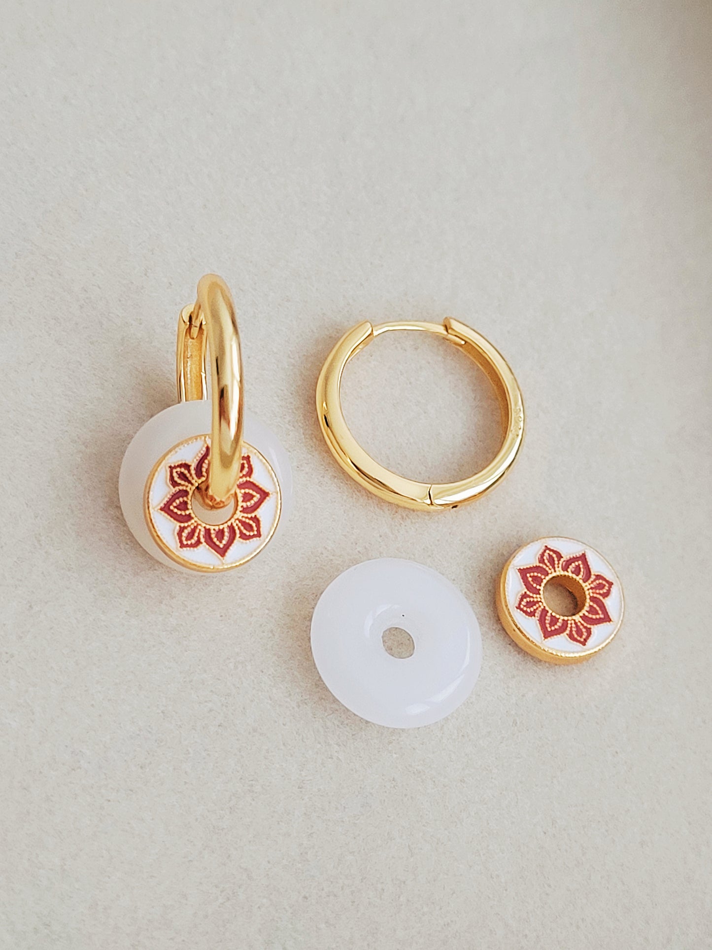 A pair of white jade and enamel disc gold hoop earrings, highlighting the art of vintage ceramic tile.