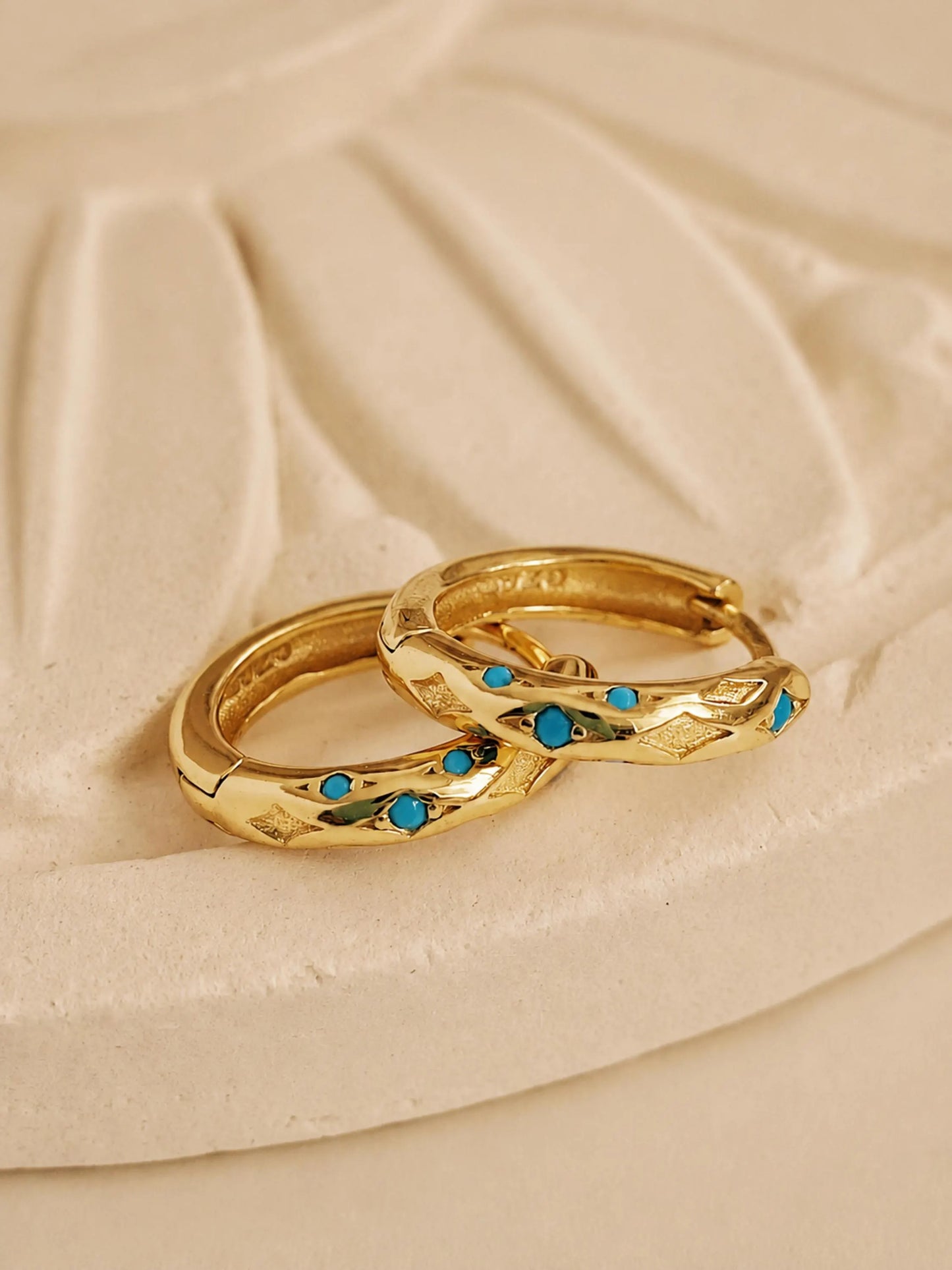 Close up of Turquoise star huggie hoop earring crafted in gold plated sterling silver, featuring a cosmic star inspired design. Minimalist earring design, perfect birthday gift for her.