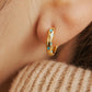 Close up of a woman wearing Turquoise star huggie hoop earring crafted in gold plated sterling silver, featuring a cosmic star inspired design. Minimalist earring design, perfect birthday gift for her.