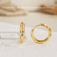 Close up of Turquoise star huggie hoop earring crafted in gold plated sterling silver, featuring a cosmic star inspired design. Minimalist earring design, perfect birthday gift for her.