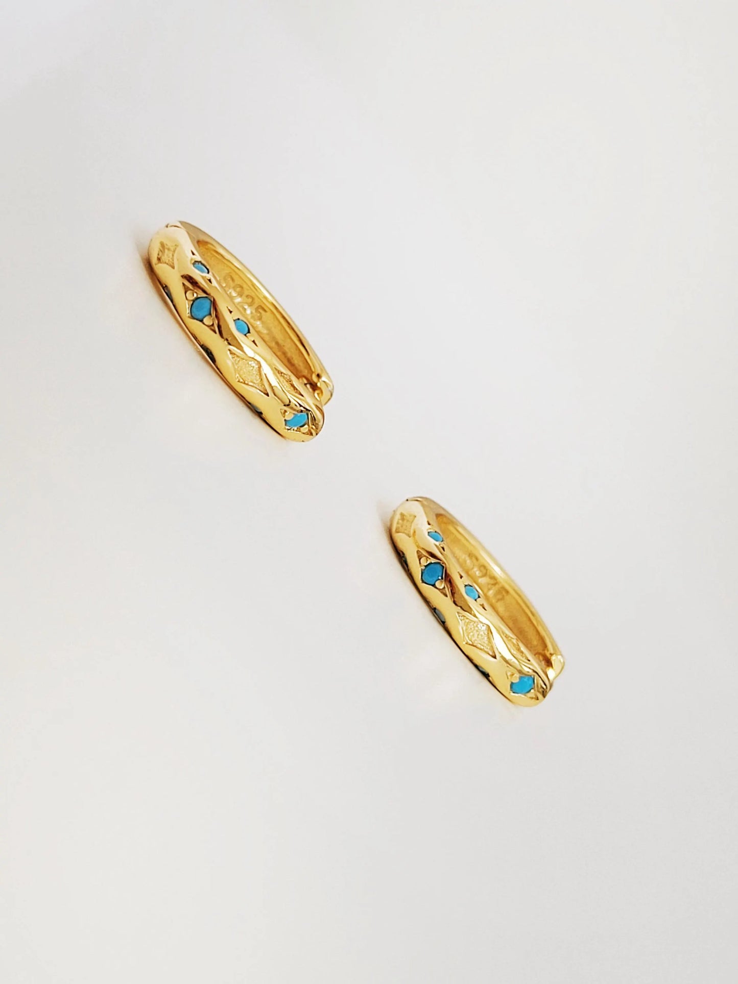 Close up of Turquoise star huggie hoop earring crafted in gold plated sterling silver, featuring a cosmic star inspired design. Minimalist earring design, perfect birthday gift for her.
