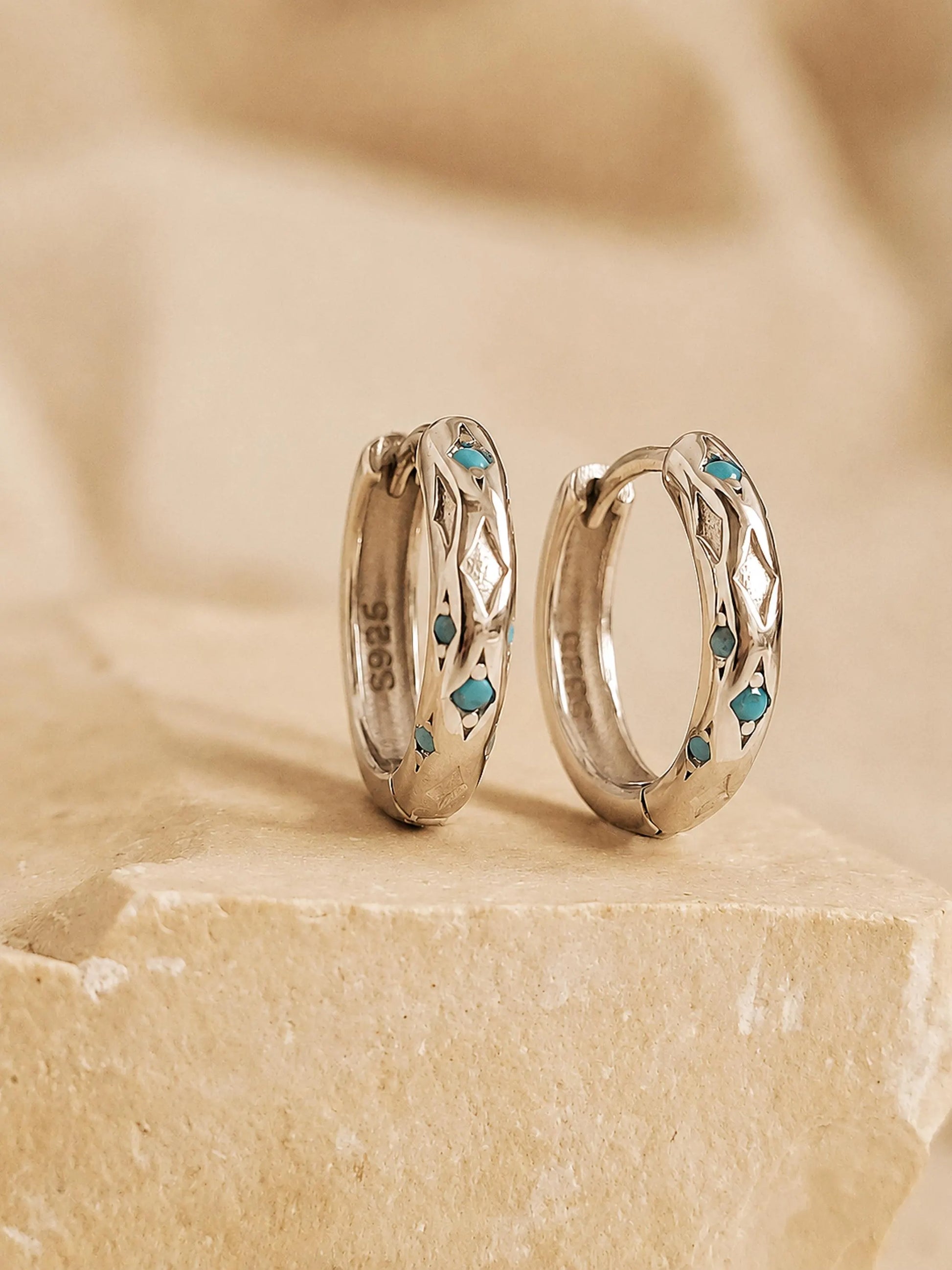 Close up of Turquoise star huggie hoop earring crafted in sterling silver, featuring a cosmic star inspired design. Minimalist earring design, perfect birthday gift for her.