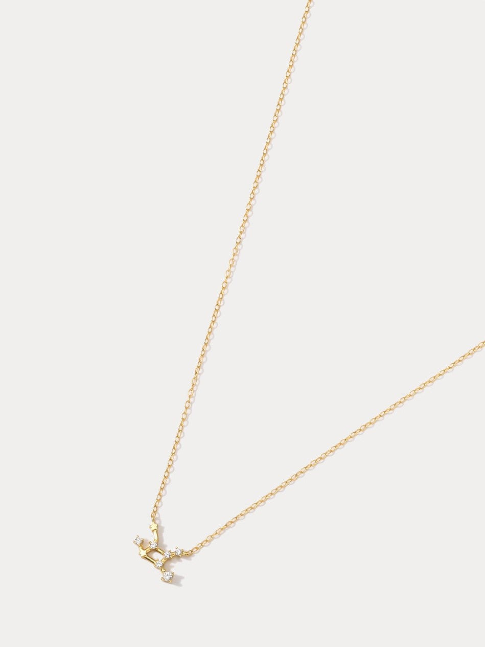 A dainty gold necklace with a pendant featuring a stylized Virgo zodiac constellation sign with sparkling zircons, crafted in gold plated sterling silver.
