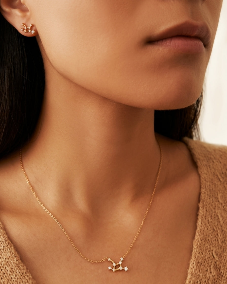 Close-up of a woman wearing a dainty gold Virgo necklace and Virgo earrings showcasing the luxury aesthetic and pendant scale. Crafted in gold vermeil, perfect jewellery gift for her.