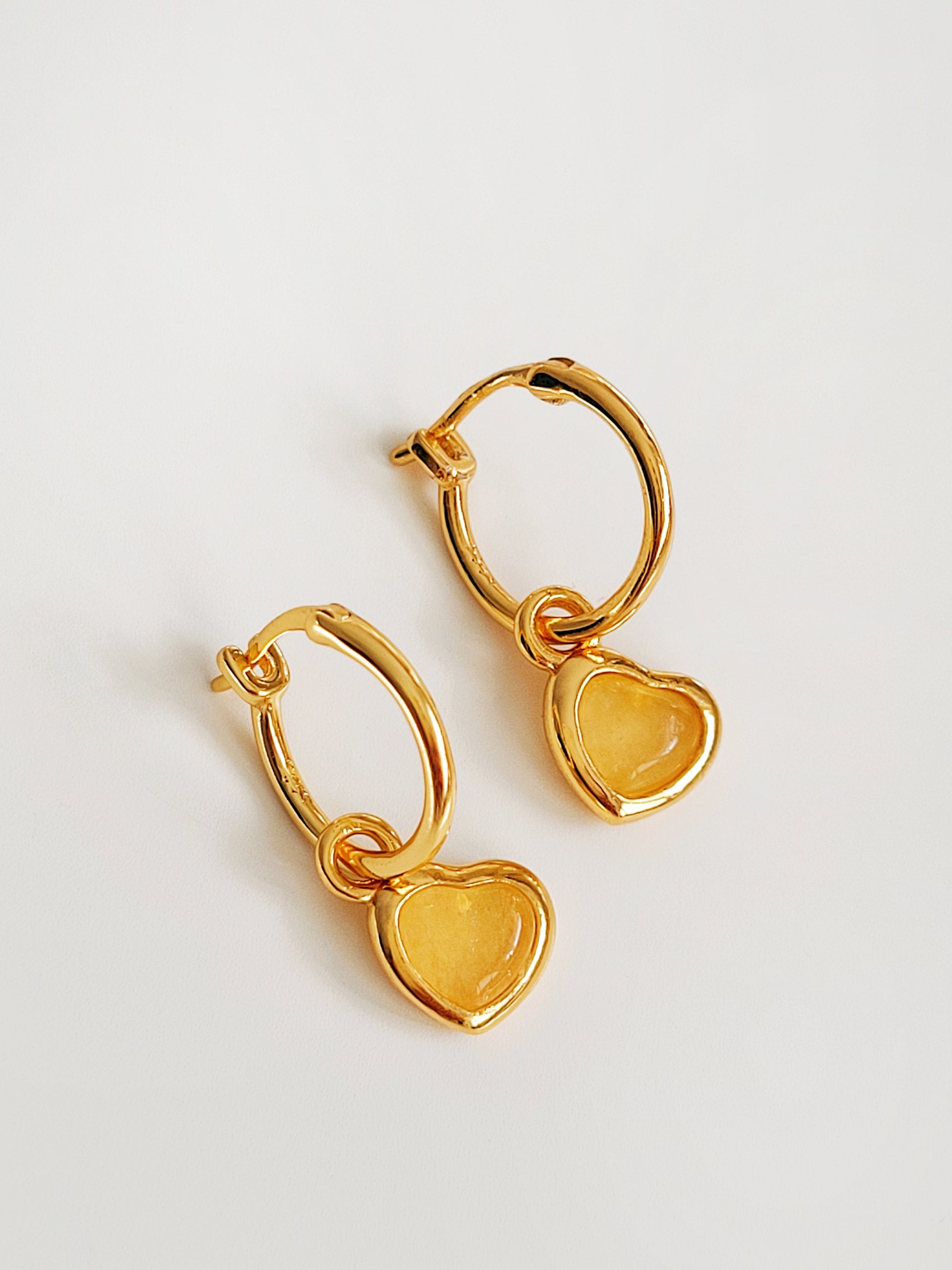 A pair of heart hoop earrings on a light gray background