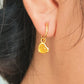 Woman wearing cute and dainty yellow heart dangle gold earrings, crafted in natural quartz crystal gemstone. Perfect anniversary gift for girl.