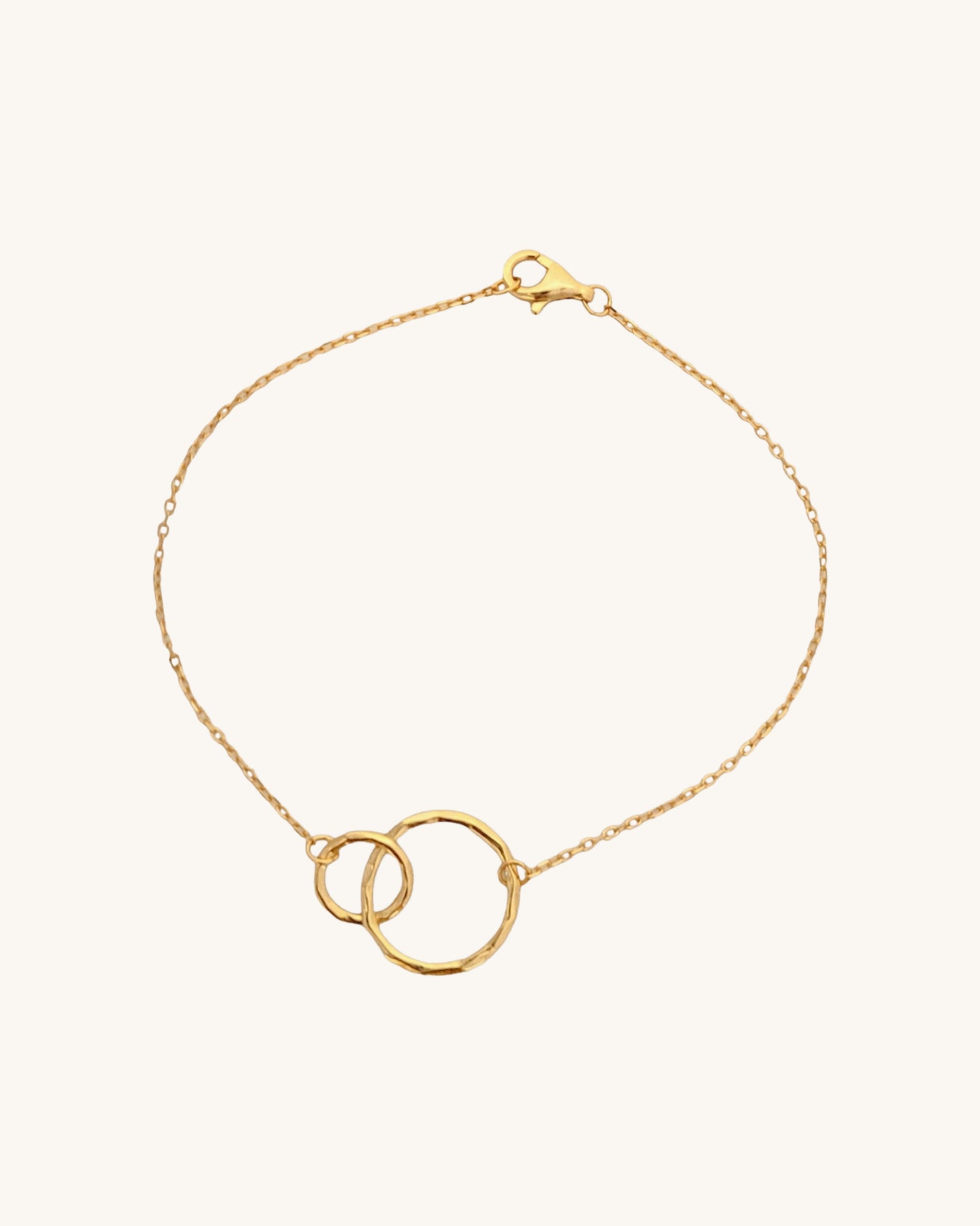Stylish double-circle gold bracelet on a paper, highlighting its simple and timeless design, perfect for everyday wear or gifting.