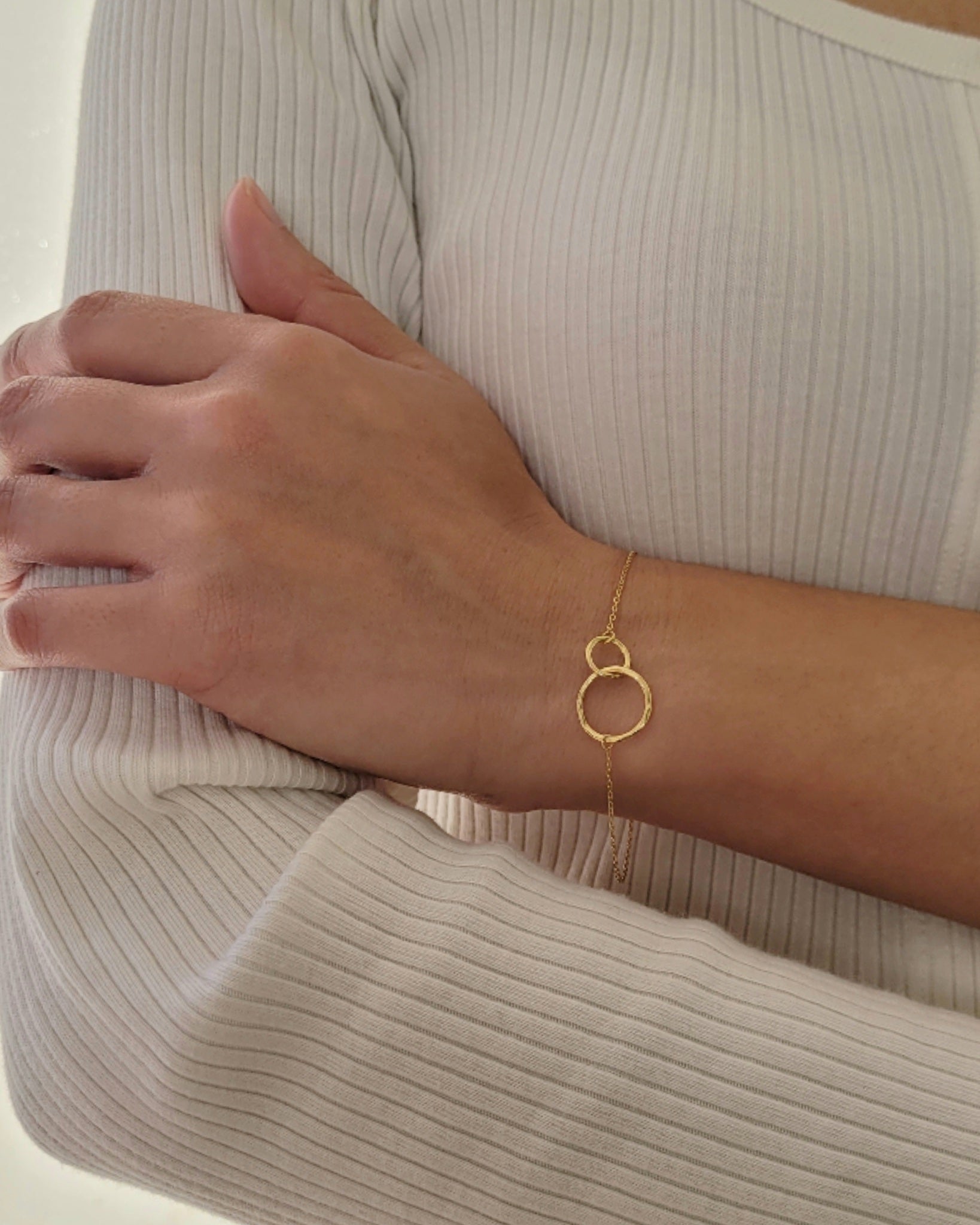 Delicate gold interlocking circle bracelet showcased on a wrist, highlighting its simple and timeless design, perfect for everyday wear or gifting