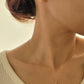Woman wearing gold pendant necklace with Paris themed details